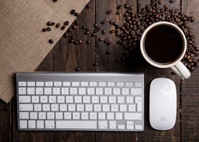 pexels-photo-585752-585752 Top view of a coffee cup with keyboard and mouse on a rustic wooden desk.