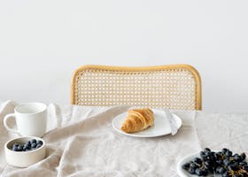 pexels-photo-7214931-7214931 Minimalist breakfast setup with croissant and blueberries on a neutral tablecloth, evoking a serene morning.